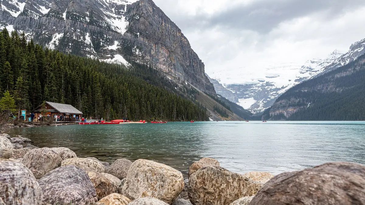 The rocky shore of Lake Louise with the Victoria Glacier behind